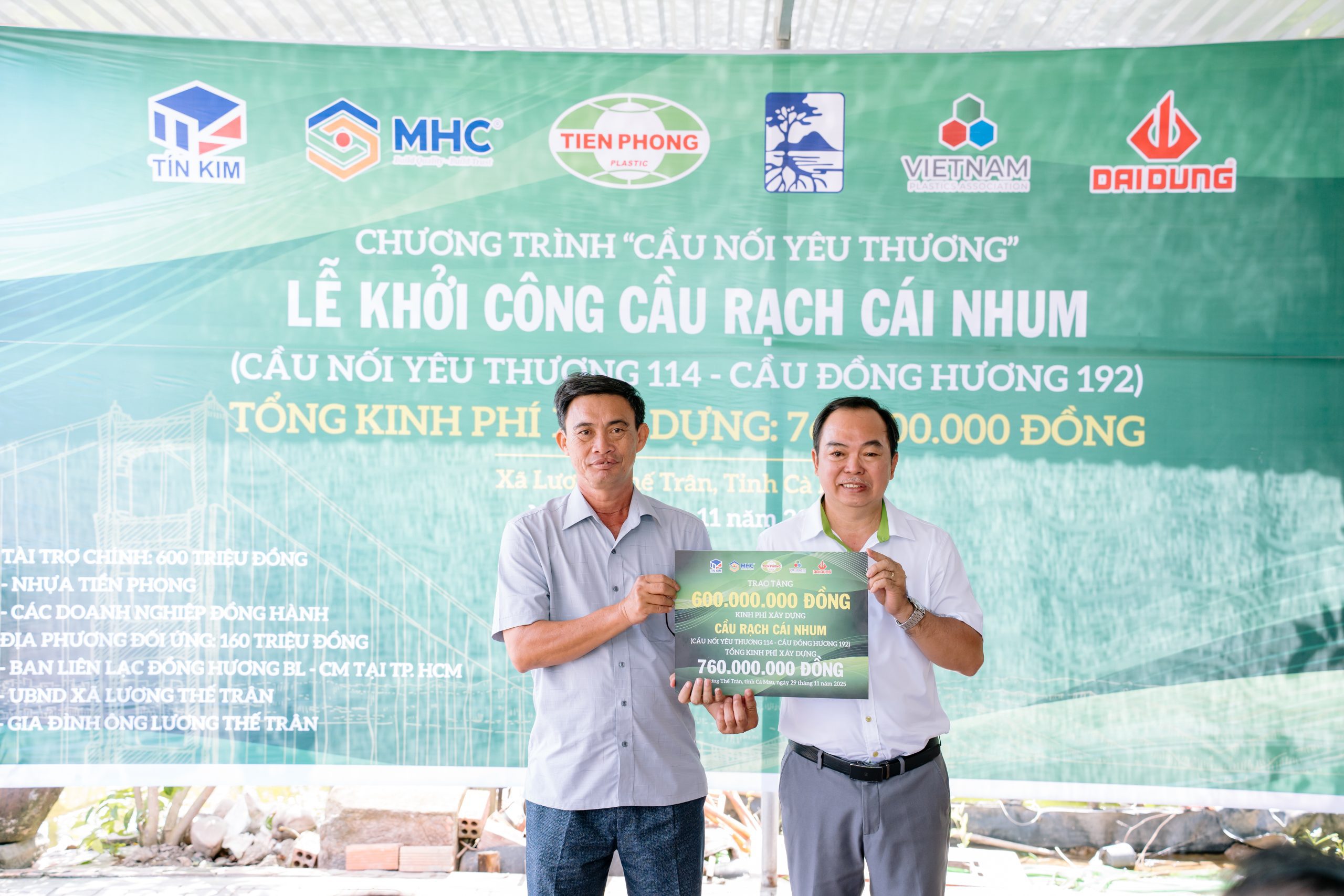 Ông Nguyễn Ngọc Tâm - Phó TGĐ Công ty CP Nhựa Thiếu niên Tiền Phong phía Nam (bên phải) trao bảng tượng trưng tặng cầu cho đại diện chính quyền xã Lương Thế Trân.